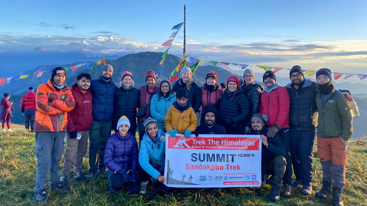 Group of trekkers celebrating Sandakphu Trek summit at 12,000 ft with Trek The Himalayas