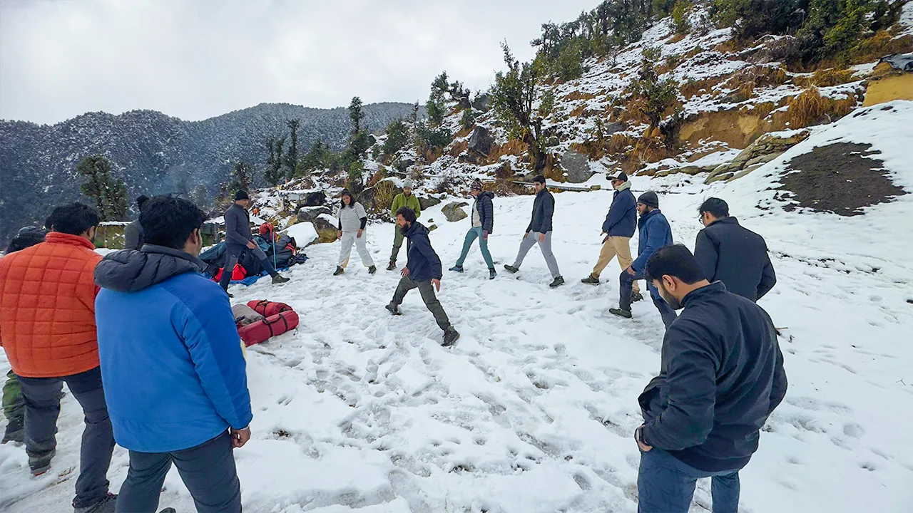 Trek leader guiding trekkers through warm-up exercises during a winter trek